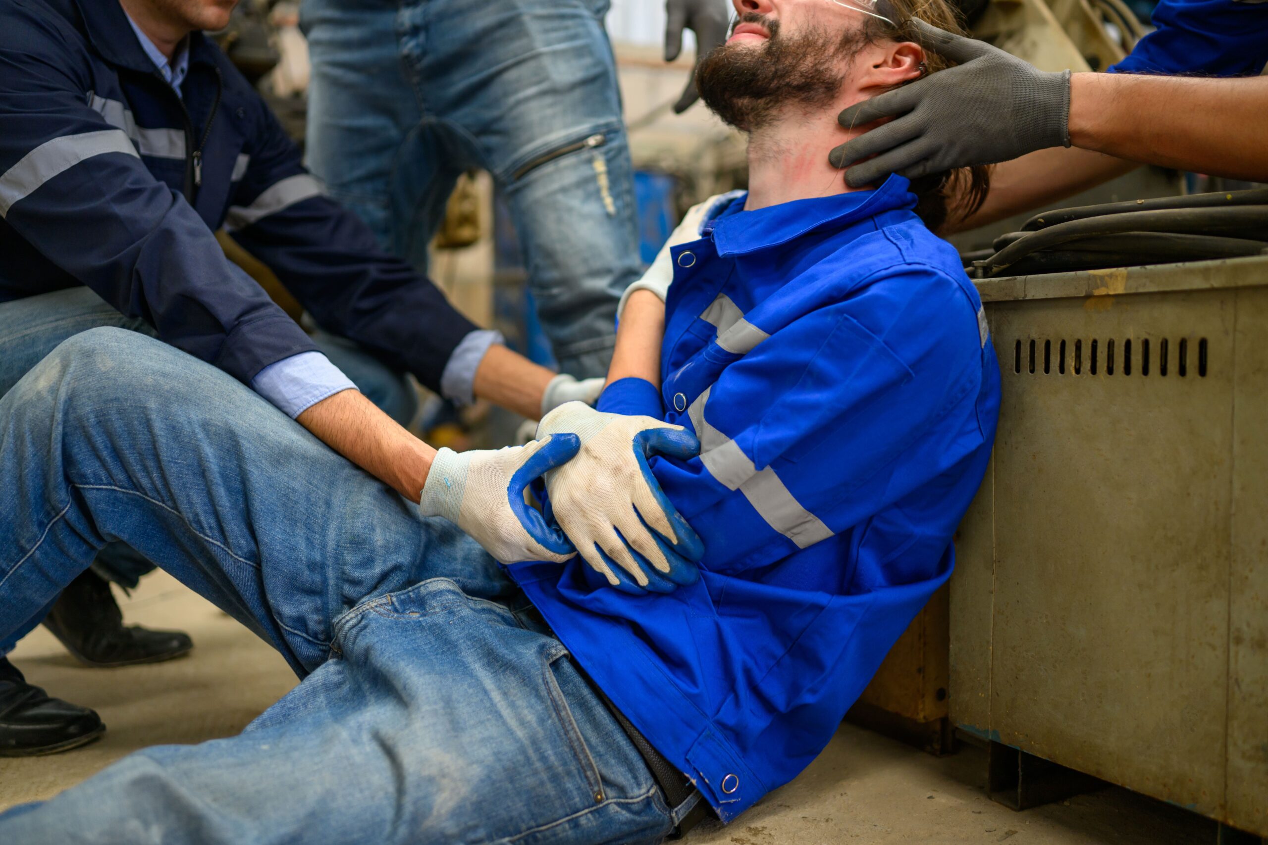 Accident du travail : collègues portant secours à un ouvrier blessé au sol.